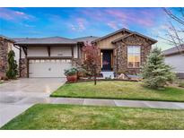 Charming home featuring a stone facade, well-maintained lawn, and an attached two-car garage at 23030 E Del Norte Cir, Aurora, CO 80016