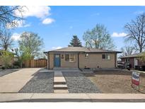 Charming brick home with a well-manicured front yard and inviting blue front door at 7496 Clay St, Westminster, CO 80030
