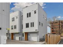 Modern townhome with gray siding, a one-car garage, and a well-maintained exterior at 3101 W 47Th Ave # 14, Denver, CO 80211