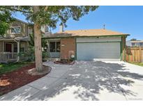 Charming single-Gathering home featuring a well-manicured lawn, brick accents, and attached two-car garage at 9125 Lowell Ct, Westminster, CO 80031