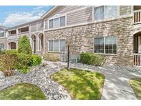 Inviting two-story condo with manicured landscaping, stone facade, and charming architectural details at 4222 S Blackhawk Cir # 6C, Aurora, CO 80014