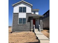 Two-story home showcasing a gray brick facade, white accents, large windows, and a vibrant red front door at 5456 N Elk St, Aurora, CO 80019