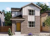 Charming two-story home featuring a brick facade, yellow door, and modern architectural details at 5456 S Elk Way, Aurora, CO 80016