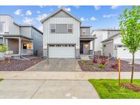 Charming two-story home featuring a two-car garage and well-manicured landscaping at 19038 E 94Th Pl, Commerce City, CO 80022