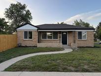 Charming brick home with a curved walkway, neat landscaping, and a well-maintained lawn at 7555 E 22Nd Ave, Denver, CO 80207