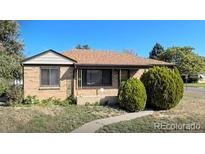Charming single-story home with a brick exterior and a well-maintained front yard, perfect for a Gathering at 7555 E 22Nd Ave, Denver, CO 80207