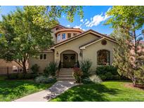 Charming home featuring a red tile roof, arched doorway, and beautifully landscaped front yard at 1035 S Elizabeth St, Denver, CO 80209