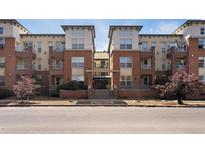 Inviting brick apartment building featuring balconies, mature trees, and attractive architectural details at 1747 N Pearl St # 306, Denver, CO 80203