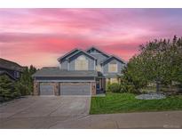 Charming two-story home with a three-car garage, landscaped yard and beautiful pink sunset at 2261 Bulrush Ct, Castle Rock, CO 80109