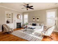 Bright living room features hardwood floors, a fireplace, and comfortable seating at 8628 E 25Th Dr, Denver, CO 80238