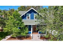 Charming blue home with a welcoming front porch and lush green trees at 1519 16Th St, Boulder, CO 80302