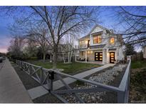 Beautiful modern farmhouse with white siding, black accents, and a charming fenced front yard at 2948 S Clarkson St, Englewood, CO 80113