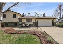 Charming two-story home with a well-manicured front yard, covered front porch, and an attached two car garage at 8898 W Harvard Pl, Lakewood, CO 80227