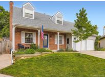 Charming brick home with a welcoming front porch, dormer windows, and a well-maintained lawn at 5456 E Briarwood Pl, Centennial, CO 80122