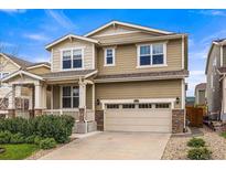 Charming two-story home featuring a front porch, two-car garage and manicured landscaping at 19722 W 59Th Ave, Golden, CO 80403