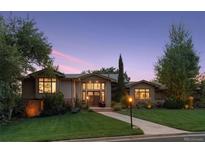 Charming home with a manicured lawn, mature trees, and inviting entrance at 4225 S Eudora St, Englewood, CO 80113