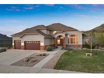Charming home featuring an attached three car garage, manicured lawn, and stone accents at 223 Castlemaine Ct, Castle Rock, CO 80104