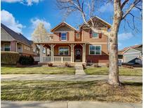 Charming two-story home featuring a welcoming front porch and a well-maintained lawn on a sunny day at 342 Olympia Ave, Longmont, CO 80504