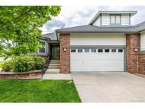 Charming home featuring a two-car garage, brick accents, and a well-manicured lawn and garden at 8267 S Sicily Ct, Aurora, CO 80016