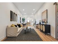 Bright living room featuring modern decor, hardwood floors and an open floor plan flowing into the kitchen at 717 Inca St, Denver, CO 80204