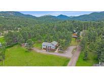 Aerial view of the home nestled in a serene wooded area at 4724 Hopi Rd, Indian Hills, CO 80454