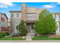Charming two-story home showcasing a modern design with stone accents and a beautifully landscaped front yard at 3384 Cranston Cir, Highlands Ranch, CO 80126