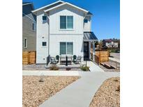 Charming two-story home featuring modern farmhouse architectural details and a cozy front porch seating area at 10534 Oncilla Ln, Lone Tree, CO 80124