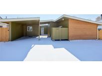 Charming single-story home with modern design, featuring a carport and fresh snow at 5350 E 66Th Way, Commerce City, CO 80022