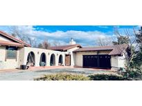 Charming stucco home with a red tile roof, arched entryway, and a well-manicured front yard at 7194 S Himalaya Way, Centennial, CO 80016