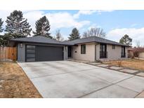 Charming single-story home featuring a modern garage door, inviting walkway, and updated exterior paint at 3049 S Vine St, Denver, CO 80210