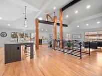 Bright, open living space with exposed beams, hardwood floors, and modern pendant lighting at 3049 S Vine St, Denver, CO 80210
