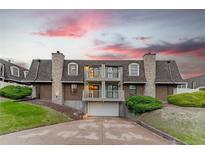 Inviting two-story townhome with balconies, a garage, stone accents, and lush landscaping at 15491 E Wyoming Dr # A, Aurora, CO 80017