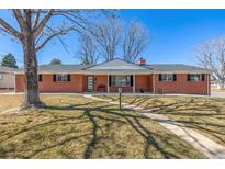 Charming ranch style home featuring a brick facade, manicured lawn, and mature trees, creating a welcoming curb appeal at 403 S Niagara St, Denver, CO 80224