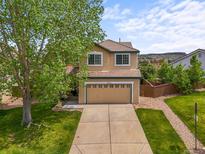 Two story home with a well manicured lawn, mature tree, and a two car garage at 4963 Collingswood Dr, Highlands Ranch, CO 80130