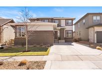 Inviting two-story home with brick accents, well-manicured lawn, and a spacious driveway at 18926 W 93Rd Ave, Arvada, CO 80007