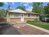 Charming home featuring a well-manicured lawn, brick accents, and a welcoming walkway to the front door at 4591 S Pennsylvania St, Englewood, CO 80113