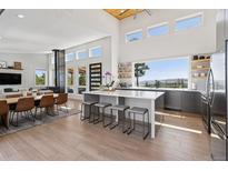 Open-concept kitchen features an island with seating and oversized windows offering scenic views at 2536 N State Highway 67, Sedalia, CO 80135