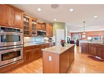 Modern kitchen features stainless steel appliances, granite countertops, and rich wood cabinetry at 8796 E 150Th Ct, Thornton, CO 80602