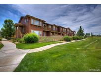 Charming townhouse with a well-maintained lawn and walkway leading to the entrance at 10451 Truckee St # 2D, Commerce City, CO 80022