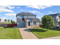 Charming two-story home with blue siding, a well-maintained lawn, and an attached one car garage at 7977 Emerson Ave, Frederick, CO 80530