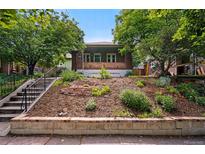 Charming brick home with terraced front yard, lush greenery, and inviting curb appeal at 3321 Stuart St, Denver, CO 80212