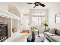 Bright living room with fireplace, plush sofa, and ample natural light from large windows at 9852 E Idaho St, Aurora, CO 80247