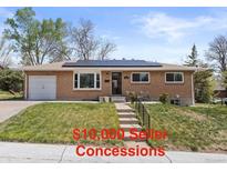 Charming brick home with a well-manicured lawn and solar panels installed on the roof at 4102 W Eastman Ave, Denver, CO 80236