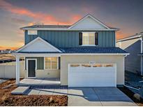 Charming two-story home featuring blue siding and a welcoming front porch at sunset at 3869 N Shawee St, Aurora, CO 80019