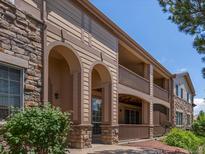 Inviting condo exterior featuring stone accents, private balconies, and neutral-tone siding at 7131 S Wenatchee Way # C, Aurora, CO 80016