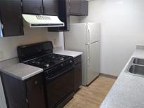 The kitchen features dark cabinetry, light countertops, and standard white appliances including a range and refrigerator at 10772 E Exposition Ave Ave # 342, Aurora, CO 80012