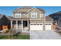 Charming two-story home showcasing a well-manicured lawn, attached three car garage, and inviting front porch at 16345 Milwaukee St, Thornton, CO 80602