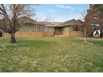 Charming ranch-style home with green siding and brick accents, set on a spacious lawn at 12337 2Nd St, Parker, CO 80134
