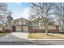 Inviting townhome with a well-maintained lawn, attached garage, and brick accents at 5243 Union Ct # 4, Arvada, CO 80002