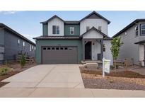 Inviting two-story home featuring mixed tone siding, a two-car garage, and meticulous landscaping at 8581 Eckley St, Littleton, CO 80125